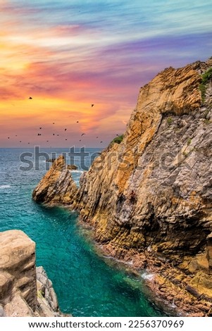 La Quebrada tourist site, famous in Acapulco, sunset in La Quebrada, with warm colors and a turquoise sea Royalty-Free Stock Photo #2256370969