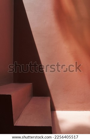 Steps by a pink wall with shadows