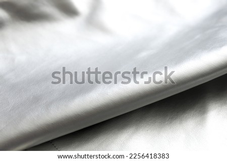 Folds on silver metal  fabric as abstract background