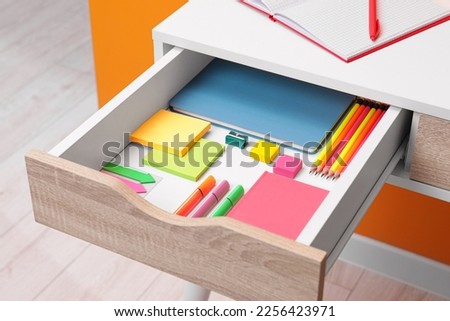 Office supplies in open desk drawer indoors Royalty-Free Stock Photo #2256423971