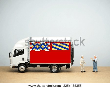 Mini toy at table with white background. Industrial shipping concept. Dijon flag design, is the prefecture of the Côte-d'Or department and of the Bourgogne-Franche-Comté region in eastern France.