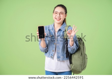 Photo of young Asian college girl on green background
