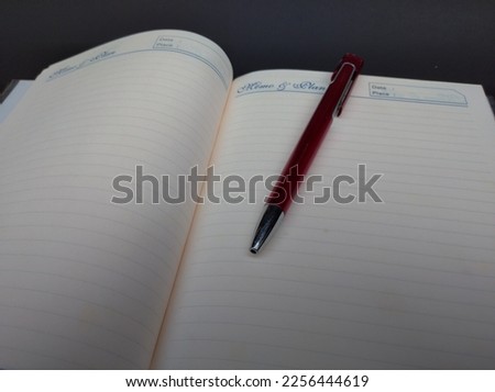 Blank notebook and red pen