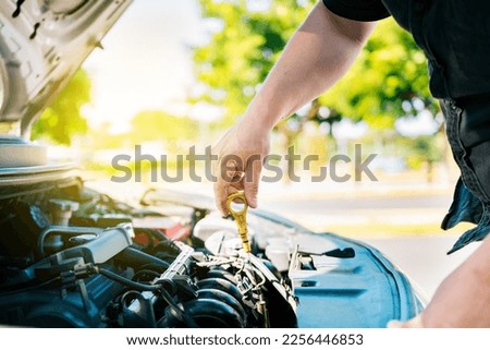 Man hand checking oil to car with copy space. People hand inspecting car oil level. Driver hand inspecting car oil level Royalty-Free Stock Photo #2256446853