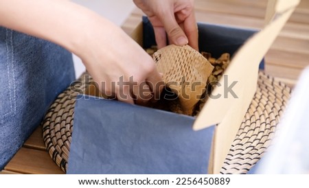 Eco vendor go green packaging parcel carton box in net zero waste store asian seller retail shop. Earth care day small SME owner asia people wrap reuse brown paper pack gift reduce plastic free order. Royalty-Free Stock Photo #2256450889
