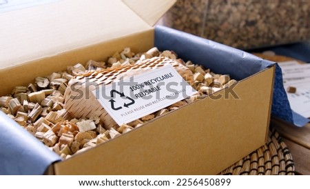 Net zero waste go green SME use eco friendly care sign plastic free symbol packaging carton box wrap paper in small shop retail store. Chva dried water hyacinth on desk reuse packing parcel supplies. Royalty-Free Stock Photo #2256450899