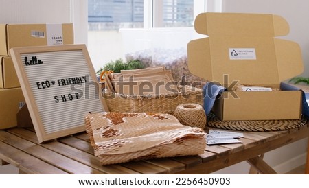 Net zero waste go green SME use eco friendly care sign plastic free symbol packaging carton box wrap paper in small shop retail store. Chva dried water hyacinth on desk reuse packing parcel supplies.