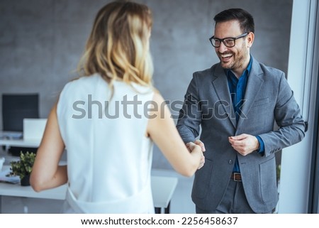 Portrait of cheerful young manager handshake with new employee. Close up of handshake in the office. Smiling businessman shaking hands while standing in an office. Handshake for the new agreement