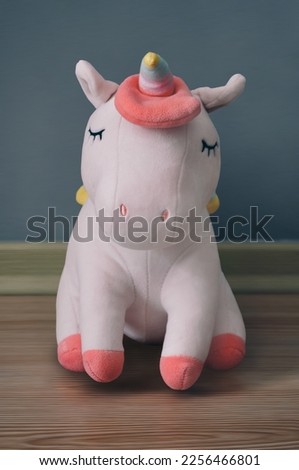 Cute soft unicorn plush toy on the floor. Close up shot