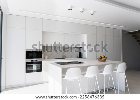 Modern minimalist marble white kitchen, minimalist interior design. Modern furniture with accessories and various utensils, table and chairs in the dining room.concept of modern and white kitchen.