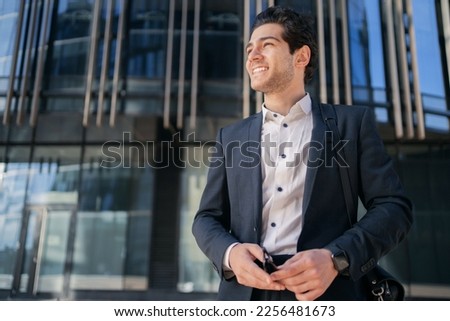 A confident CEO male manager walking into the office in a formal suit smiles, thinks about the prospects. Royalty-Free Stock Photo #2256481673