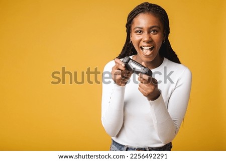 Photo of happy excited crazy smiling woman playing videogames addicted to playstation isolated on yellow colour background