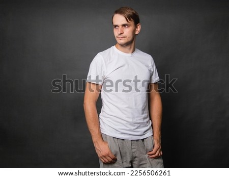 Young man in a white t-shirt on a gray background.Mock-up.