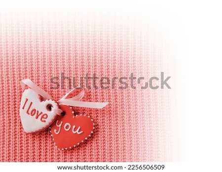 Two heart-shaped cookie making the I love you inscription on a red background. White vignette design. Top view