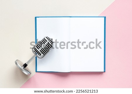 Recording audiobook or podcast with microphone and book, top view.