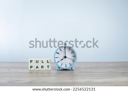 Concept on choice. FullPart words on white cubes with an alarm clock.  Full time or part time