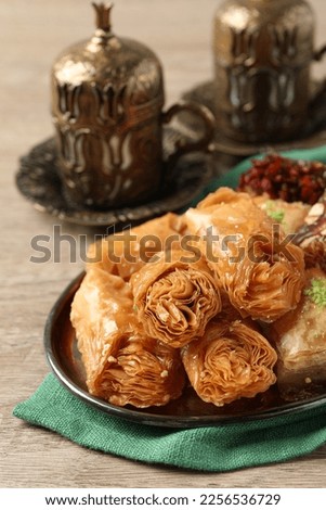 Tea and baklava dessert and Turkish delight served in vintage tea set on wooden table, closeup. Space for text