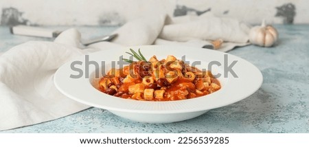 Bowl with tasty pasta and beans on light background