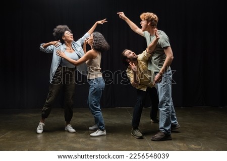full length of young multiethnic actors posing while rehearsing in acting skills school Royalty-Free Stock Photo #2256548039