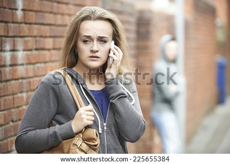 Teenage Girl Using Phone As She Feels Intimidated On Walk Home Royalty-Free Stock Photo #225655384
