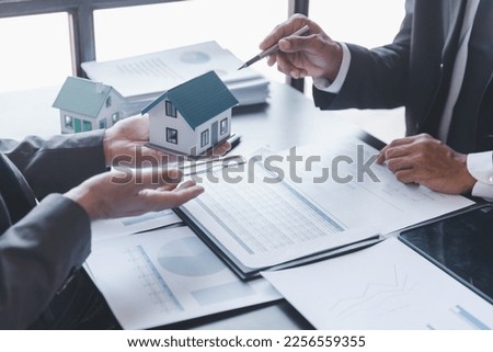 Business property,real estate and investment concepts. Real estate agent present terms of the home purchase agreement to customer,investor discussing real estate investment
