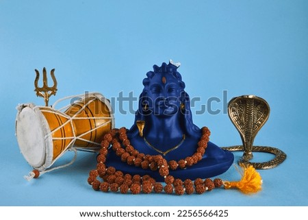 Shivaratri background with Shivas trident, Pellet Drum Damroo musical instrument ans snake . Maha Shivratri festval Royalty-Free Stock Photo #2256566425