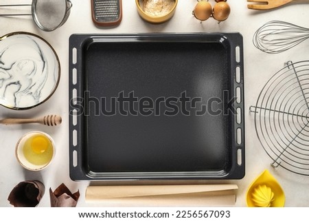 Baking tray with ingredients and utensils on white background Royalty-Free Stock Photo #2256567093