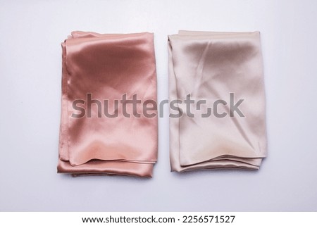 Two folded silk pillow covers, soft pink silk pillowcases Royalty-Free Stock Photo #2256571527