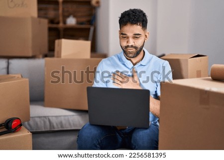 Young hispanic man having video call communicating with deaf language at new home