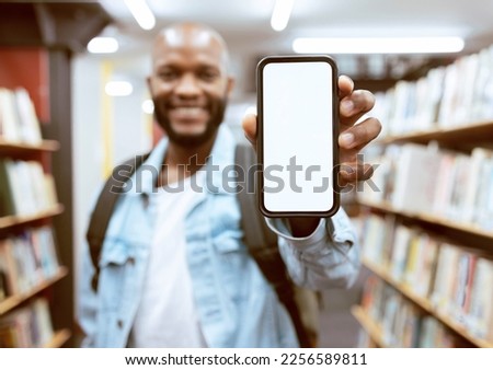 Mockup screen, education or black man with phone in library for research, advertising or project management. Smile, happy or university student with tech for learning, scholarship study or web search