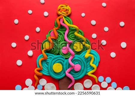 Plasticine Christmas tree and snow on red background, flat lay