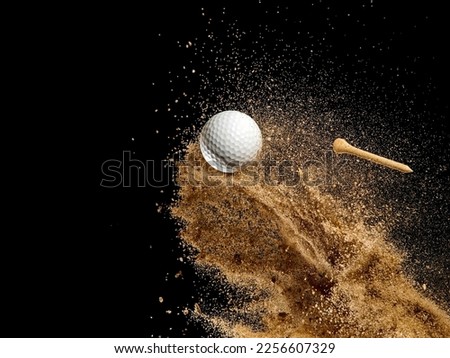 White golf ball in golden dry sand explosion on black background Royalty-Free Stock Photo #2256607329