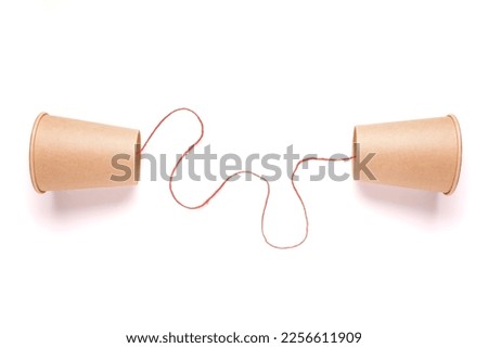 Old style cup phone with red string on white background, two way communication, information transmission, sender and receiver, communicate with each other Royalty-Free Stock Photo #2256611909