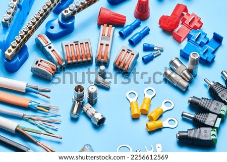 Different electrical tools isolated on blue background, electrician equipment, wires, terminals, connectors, fuses, switches Royalty-Free Stock Photo #2256612569