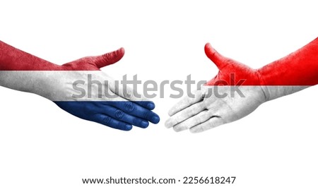 Handshake between Indonesia and Netherlands flags painted on hands, isolated transparent image.
