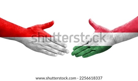 Handshake between Hungary and Indonesia flags painted on hands, isolated transparent image.