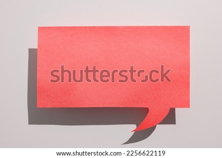 Color paper in shape of dialog box with important message. Infromation written on sticker. Different office stationery. Calculator, pencils, pens laing white table.