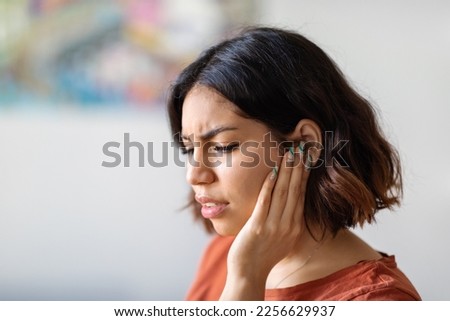 Ears Pain. Sick Young Arab Woman Suffering From Earache At Home, Upset Middle Eastern Female Having Otitis Illness And Healthcare Problems, Millennial Lady Frowning While Rubbing Sore Auricle Royalty-Free Stock Photo #2256629937