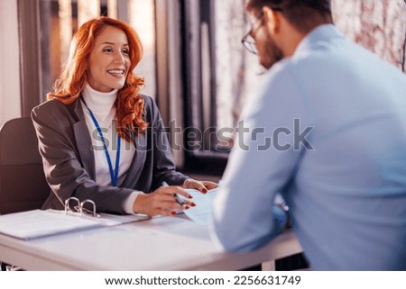 Business people man and woman sitting at the table in the office and signing the contract.