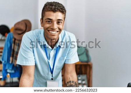 Young hispanic man working as shop assistant at retail shop Royalty-Free Stock Photo #2256632023