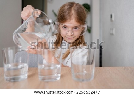 Kid making chemical experiments or tests home, improving knowledge, studying in playful manner, homeschooling concept. Royalty-Free Stock Photo #2256632479