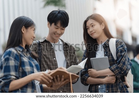Beautiful young Asian woman college student with friends at outdoors. College student working on the college campus Royalty-Free Stock Photo #2256634039