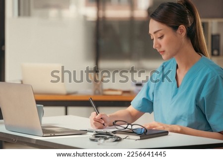 Female doctor writing a letter of referral for a patient.