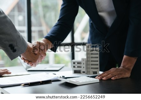 Successful purchase agreement. Real estate agent shaking hands with his client. 