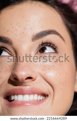 Cropped view of dreamy and freckled woman looking up Royalty-Free Stock Photo #2256664289