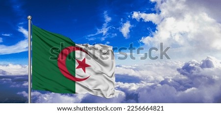 Algeria national flag cloth fabric waving on beautiful sky background.