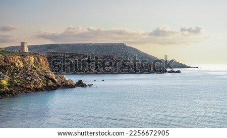 A landscape picture in Malta over looking the sea and tower of St John