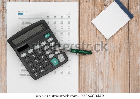The concept of an accounting audit. calculator and magnifying glass on the financial statement and the annual balance sheet on the auditor's desk. Royalty-Free Stock Photo #2256680449