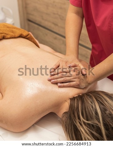 Male therapist doing neck massage to woman in beauty salon