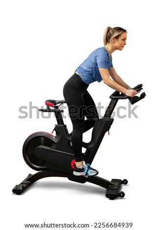 Woman exercising on a spin bike isolated on white background Royalty-Free Stock Photo #2256684939